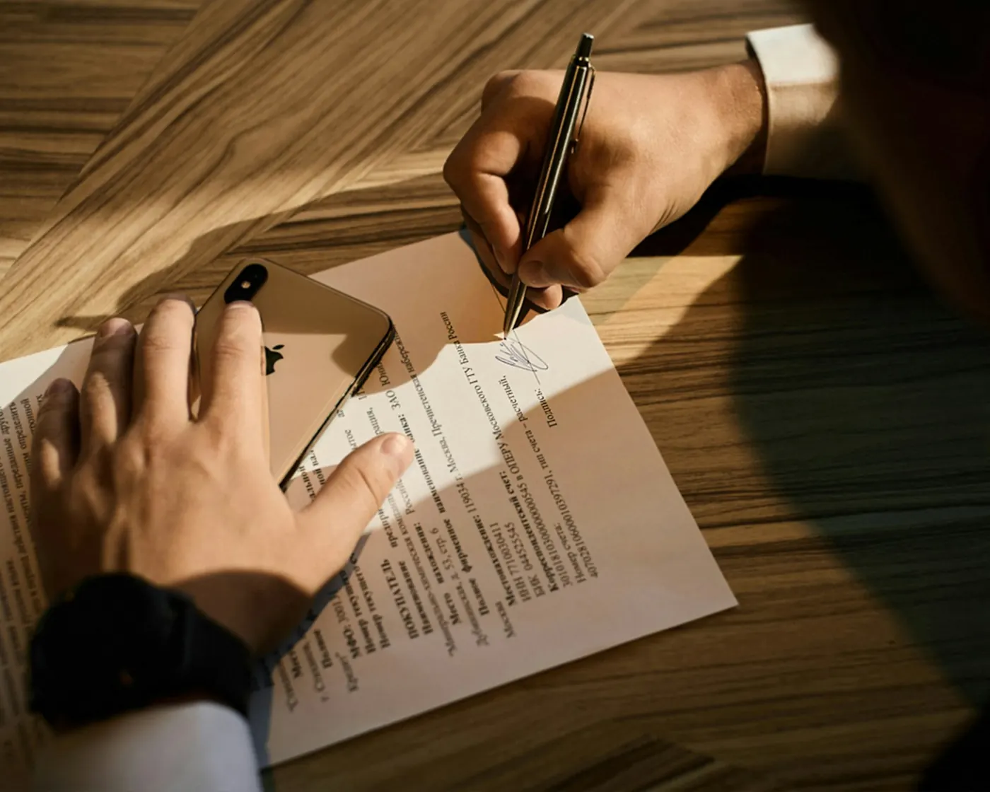 Pessoa assinando um documento sobre a mesa